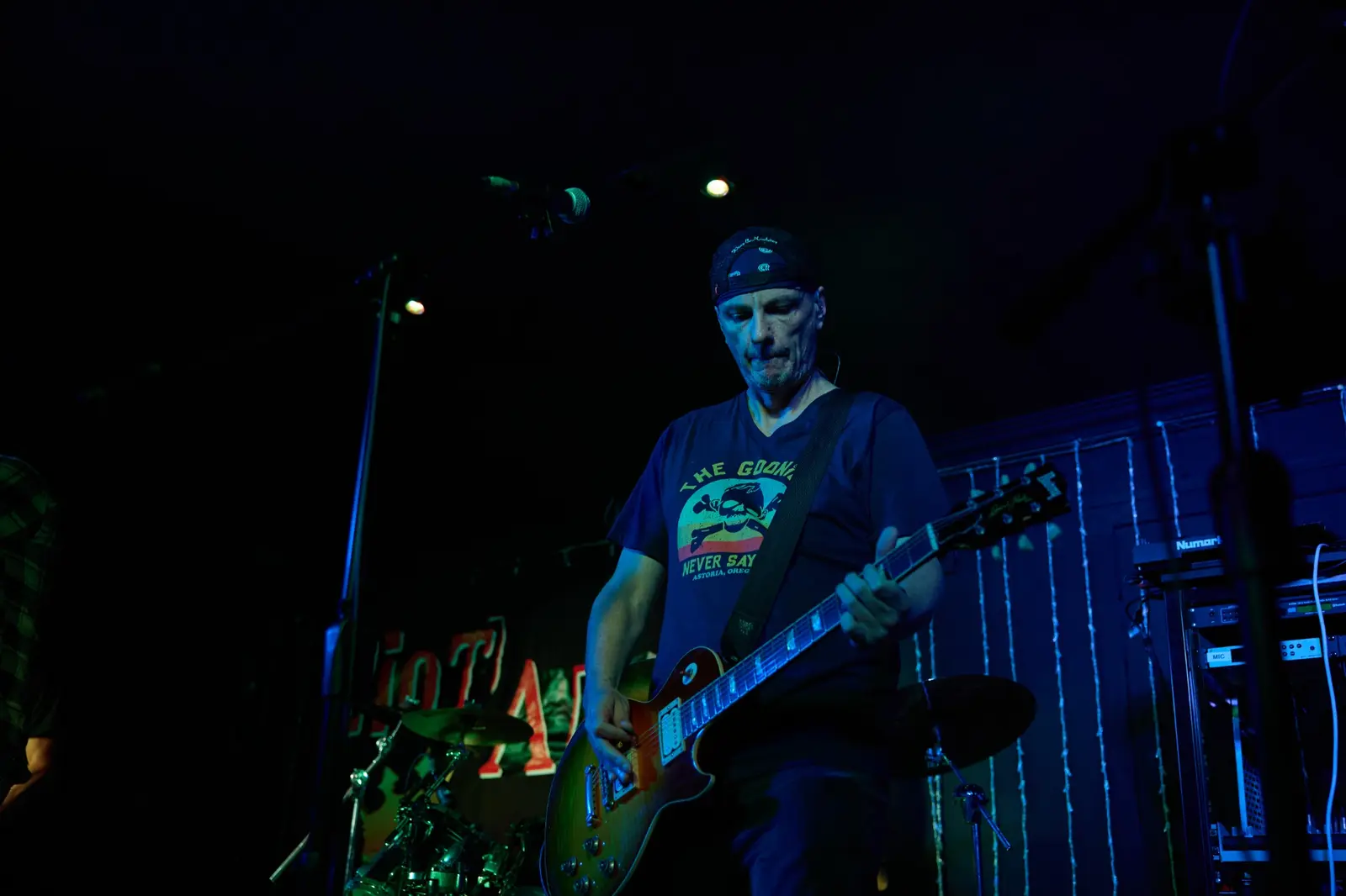 Guitarist performing live under blue stage lighting